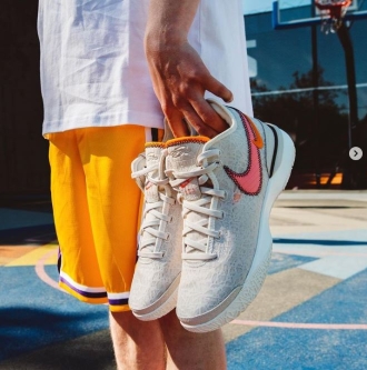 Mees seismas korvpalliplatsil ja hoidmas käes paari valgeid Nike tosse