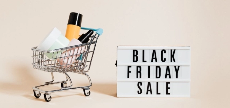 Kaubaga täidetud mini ostukäru ning Black Friday Sale silt beezil taustal