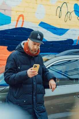 Mees auto najale toetumas ja uurimas telefoni